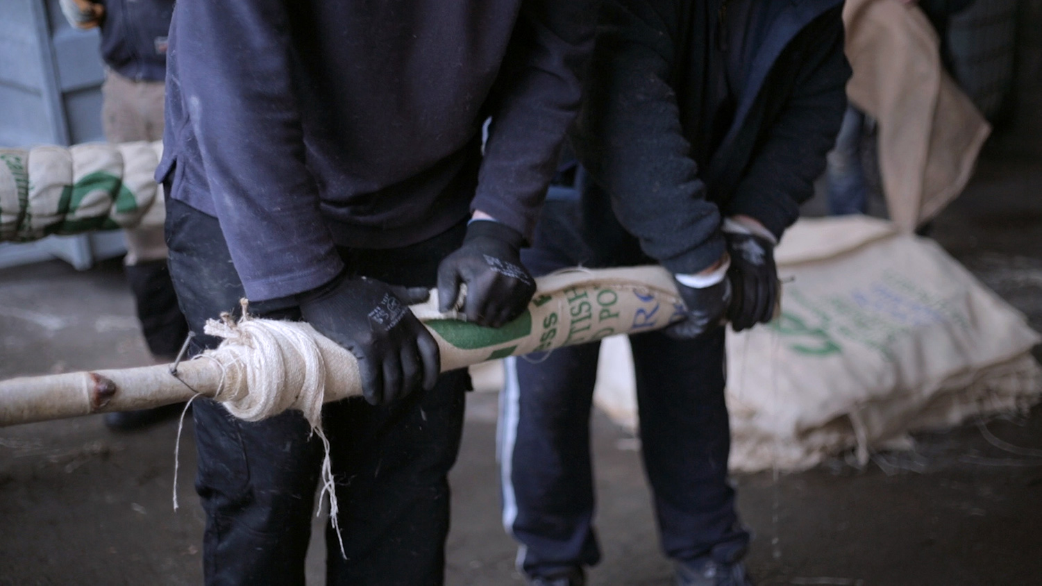 The Clock in Commune, video still, men making flambeaux torch